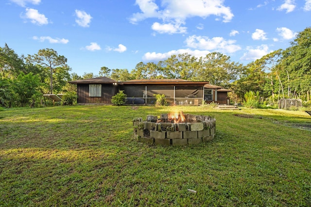 12401 174th Pl N, Jupiter, FL 33478 - view of grassy yard featuring a sunroom and an outdoor fire pit