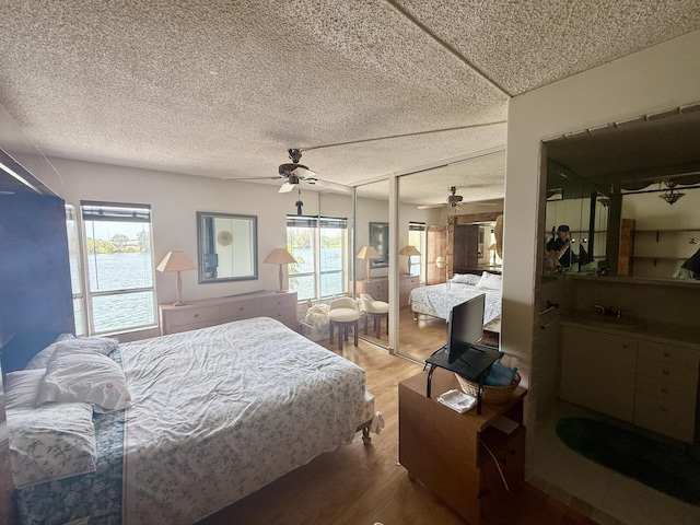 1100 Crystal Lake Dr Unit 107, Deerfield Beach, FL 33064 - bedroom with wood finished floors, a textured ceiling, and a ceiling fan