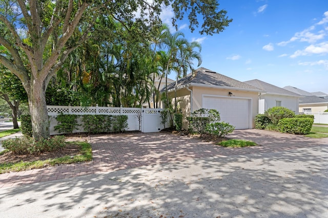 240 Honeysuckle Dr, Jupiter, FL 33458 - view of side of home featuring an attached garage, driveway, and stucco siding