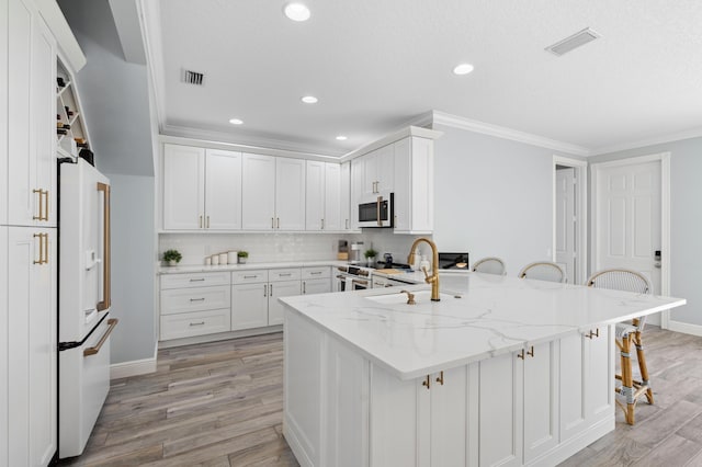 240 Honeysuckle Dr, Jupiter, FL 33458 - kitchen featuring white appliances, a kitchen bar, light stone counters, white cabinets, and crown molding
