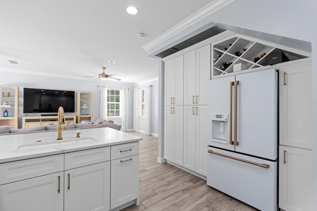 240 Honeysuckle Dr, Jupiter, FL 33458 - kitchen featuring high end white fridge, crown molding, open floor plan, a ceiling fan, and white cabinetry