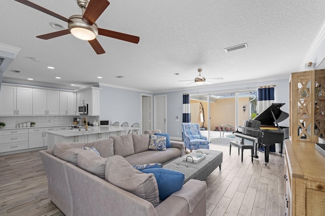 240 Honeysuckle Dr, Jupiter, FL 33458 - living area featuring ceiling fan, ornamental molding, light wood-style floors, a textured ceiling, and recessed lighting