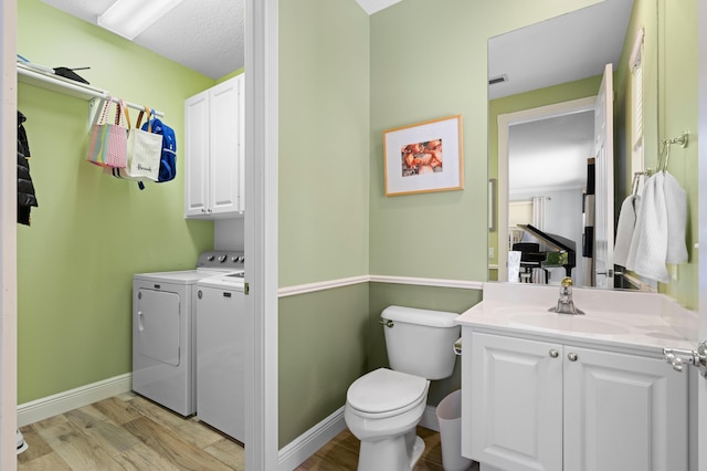 240 Honeysuckle Dr, Jupiter, FL 33458 - bathroom featuring washing machine and dryer, vanity, and wood finished floors