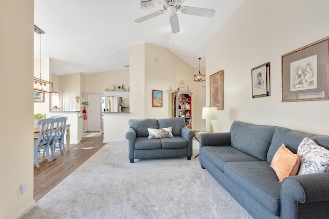 352 NW Granville St, Port Saint Lucie, FL 34986 - living area with a chandelier, ceiling fan, high vaulted ceiling, carpet flooring, and wood finished floors