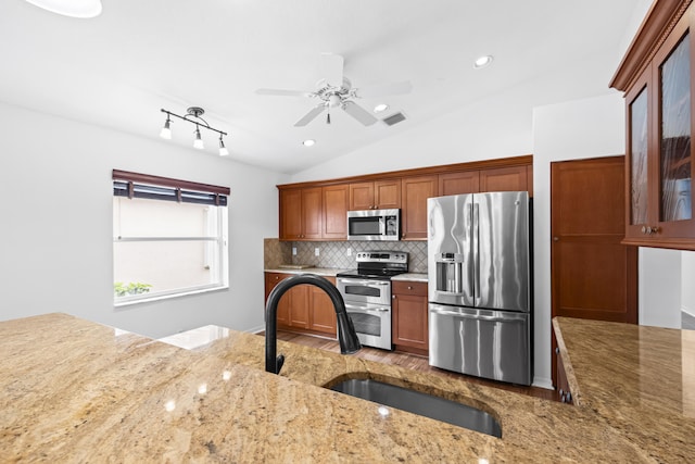 7117 Treviso Ln, Boynton Beach, FL 33472 - kitchen featuring appliances with stainless steel finishes, lofted ceiling, light stone countertops, ceiling fan, and backsplash