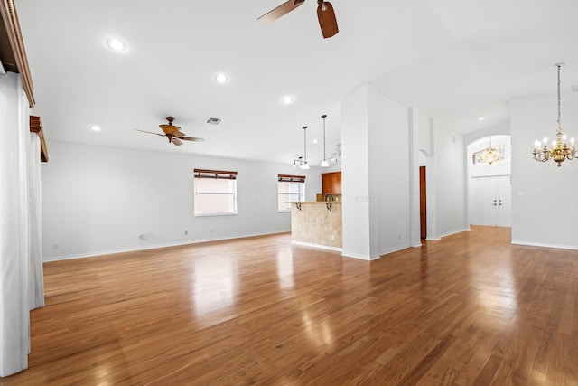 7117 Treviso Ln, Boynton Beach, FL 33472 - unfurnished living room featuring a ceiling fan, a chandelier, light wood-type flooring, arched walkways, and recessed lighting