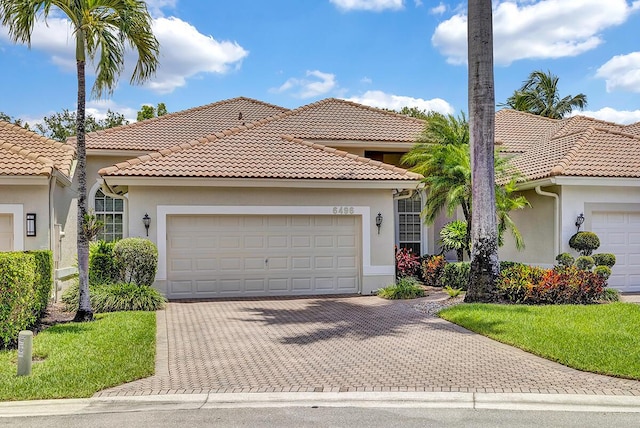 6496 San Michel Way, Delray Beach, FL 33484 - mediterranean / spanish-style house with stucco siding, decorative driveway, a garage, and a tile roof