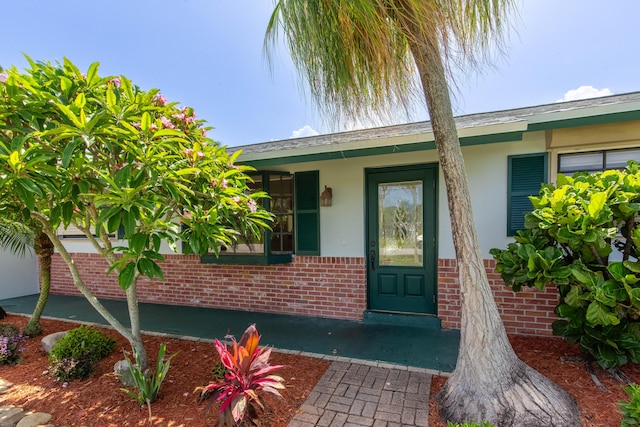 12069 Easterly Ave, Palm Beach Gardens, FL 33410 - property entrance featuring stucco siding, brick siding, and a porch