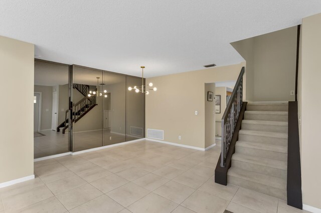 368 SW 29th Ave, Delray Beach, FL 33445 - unfurnished living room with a high ceiling, stairway, a chandelier, and tile patterned flooring