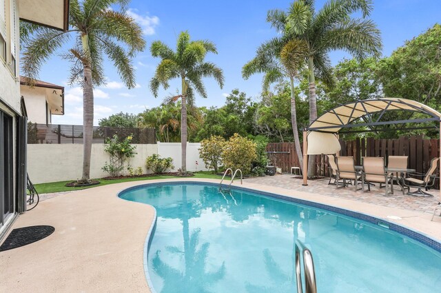 368 SW 29th Ave, Delray Beach, FL 33445 - kitchen featuring stainless steel appliances, tasteful backsplash, a kitchen island, light brown cabinetry, and light tile patterned floors