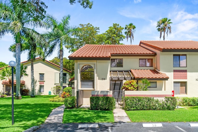 10263 N Circle Lake Dr Unit 201, Boynton Beach, FL 33437 - view of front of property with a tiled roof, a front yard, stucco siding, a gate, and uncovered parking