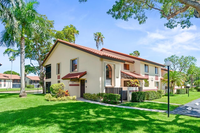 10263 N Circle Lake Dr Unit 201, Boynton Beach, FL 33437 - mediterranean / spanish house featuring a tile roof, stucco siding, and a front yard
