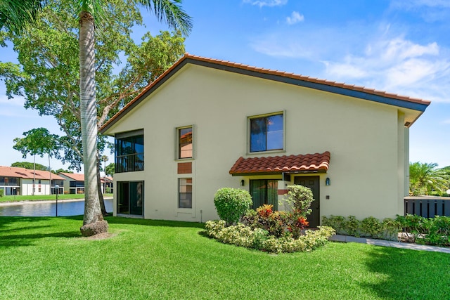 10263 N Circle Lake Dr Unit 201, Boynton Beach, FL 33437 - back of property with a water view, a tile roof, stucco siding, and a yard