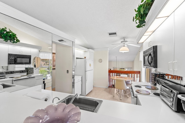 10263 N Circle Lake Dr Unit 201, Boynton Beach, FL 33437 - kitchen featuring white appliances, light countertops, white cabinets, light wood-style floors, and a textured ceiling