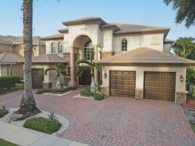 718 Edgebrook Ln, West Palm Beach, FL 33411 - mediterranean / spanish house featuring a garage, stone siding, and decorative driveway