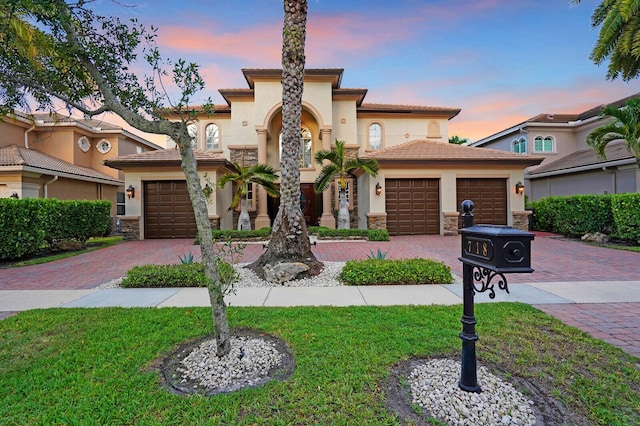 718 Edgebrook Ln, West Palm Beach, FL 33411 - mediterranean / spanish-style house featuring stucco siding, decorative driveway, a garage, and a front lawn