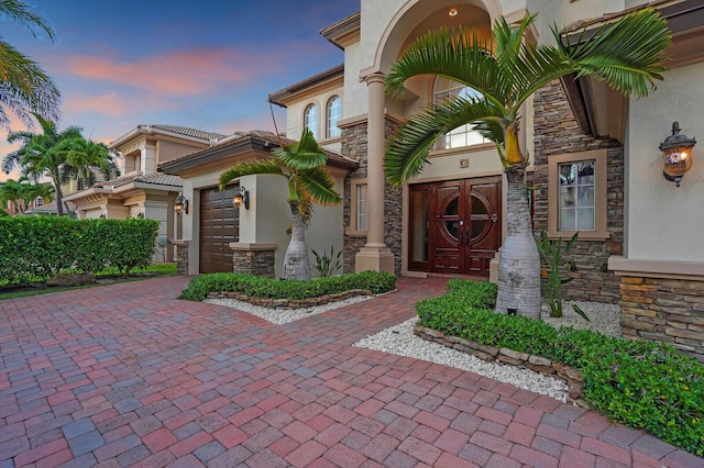 718 Edgebrook Ln, West Palm Beach, FL 33411 - view of exterior entry with stucco siding, stone siding, and decorative driveway