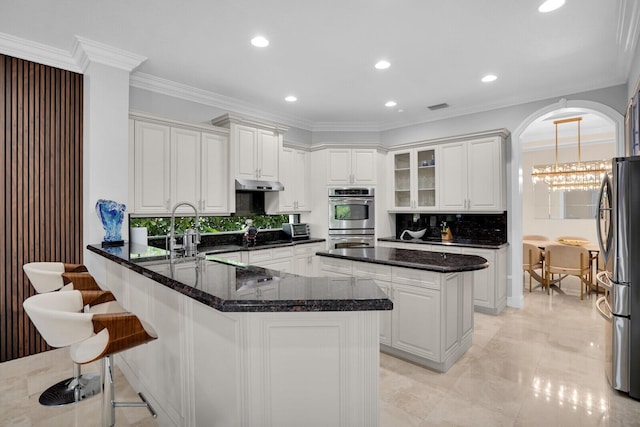 718 Edgebrook Ln, West Palm Beach, FL 33411 - kitchen featuring appliances with stainless steel finishes, under cabinet range hood, a peninsula, decorative backsplash, and white cabinetry