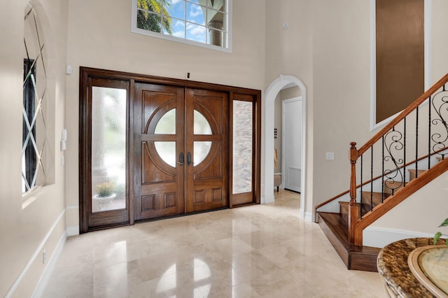 718 Edgebrook Ln, West Palm Beach, FL 33411 - foyer entrance featuring a towering ceiling, arched walkways, stairway, and marble finish floors