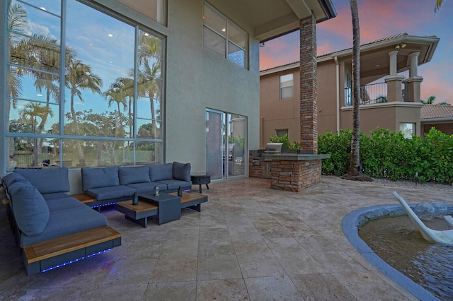 718 Edgebrook Ln, West Palm Beach, FL 33411 - patio terrace at dusk with an outdoor hangout area, exterior kitchen, and a patio
