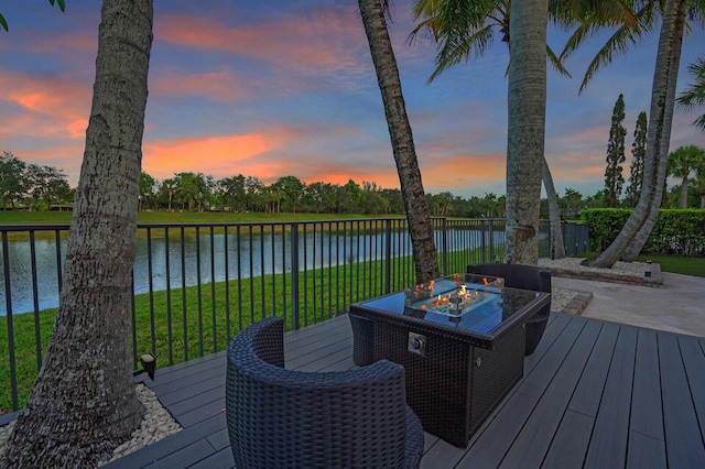 718 Edgebrook Ln, West Palm Beach, FL 33411 - deck at dusk with an outdoor fire pit, a water view, and a yard