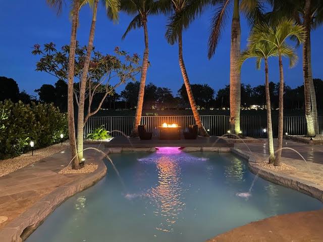 718 Edgebrook Ln, West Palm Beach, FL 33411 - pool at twilight with a fenced backyard and a patio