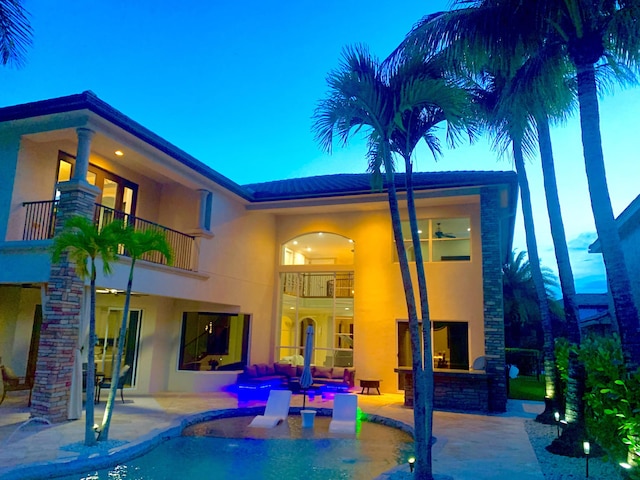 718 Edgebrook Ln, West Palm Beach, FL 33411 - back of house featuring a balcony, a patio, stucco siding, an outdoor pool, and an outdoor living space with a fireplace