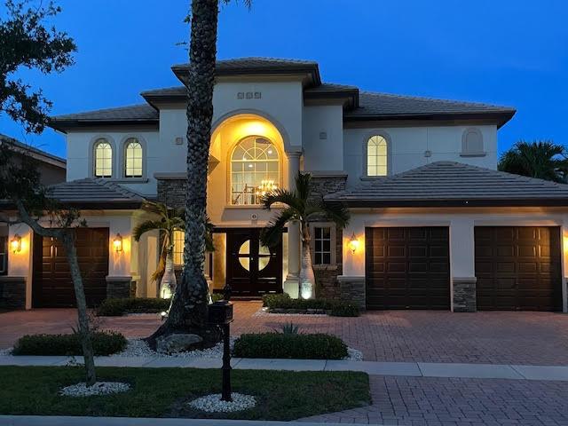718 Edgebrook Ln, West Palm Beach, FL 33411 - mediterranean / spanish home with decorative driveway, a garage, stone siding, and stucco siding
