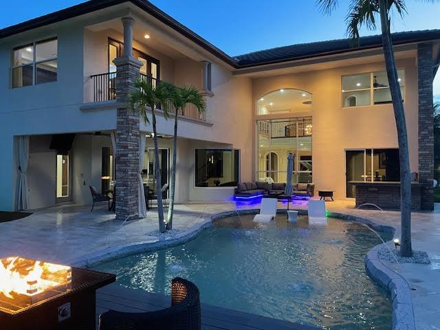 718 Edgebrook Ln, West Palm Beach, FL 33411 - back of house with a balcony, stucco siding, a patio, and an outdoor pool