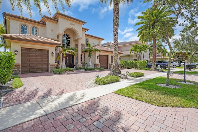 718 Edgebrook Ln, West Palm Beach, FL 33411 - mediterranean / spanish house featuring a garage, decorative driveway, and stucco siding