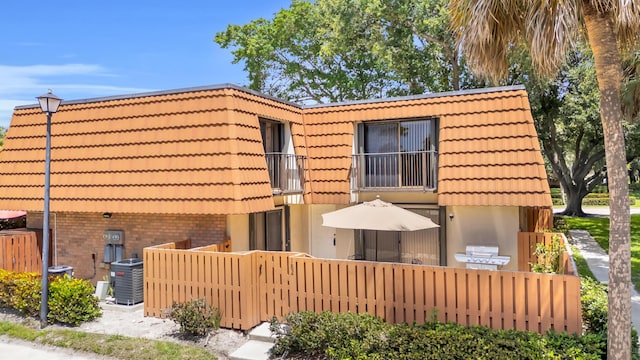 182 Charter Way, West Palm Beach, FL 33407 - back of property featuring a balcony, a fenced front yard, a tile roof, and stucco siding