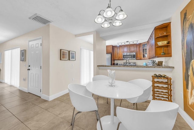 182 Charter Way, West Palm Beach, FL 33407 - dining area featuring light tile patterned flooring, a chandelier, and track lighting