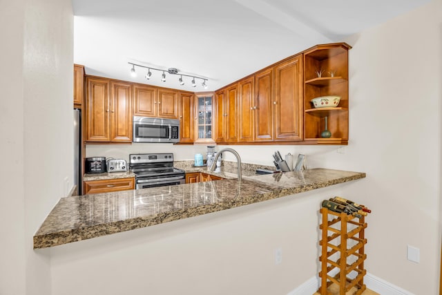 182 Charter Way, West Palm Beach, FL 33407 - kitchen featuring stainless steel appliances, a peninsula, stone counters, and glass insert cabinets