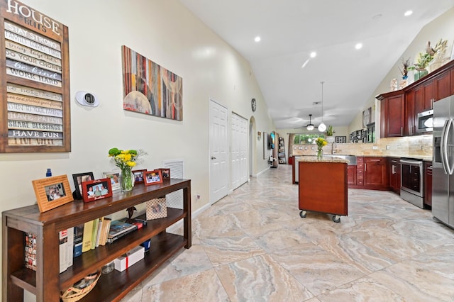 8404 Long Bay, West Palm Beach, FL 33411 - kitchen featuring stainless steel appliances, light stone countertops, decorative backsplash, ceiling fan, and a peninsula
