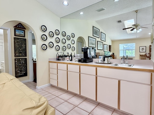 13021 150th Ct N, Jupiter, FL 33478 - kitchen with vaulted ceiling, a ceiling fan, light tile patterned floors, arched walkways, and light countertops