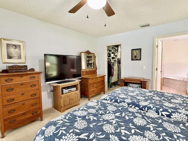 13021 150th Ct N, Jupiter, FL 33478 - bedroom featuring light carpet, a spacious closet, a closet, a textured ceiling, and a ceiling fan