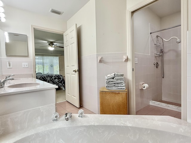 13021 150th Ct N, Jupiter, FL 33478 - bathroom featuring tile walls, tile patterned floors, a ceiling fan, double vanity, and a tile shower