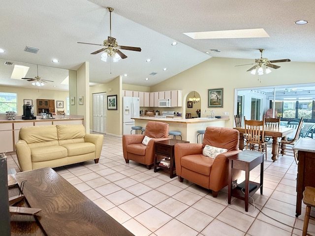 13021 150th Ct N, Jupiter, FL 33478 - living room featuring a skylight, a ceiling fan, vaulted ceiling, light tile patterned flooring, and recessed lighting