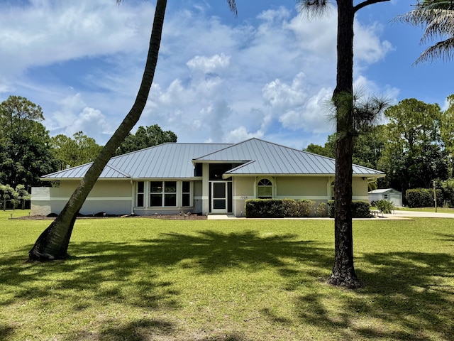 13021 150th Ct N, Jupiter, FL 33478 - view of front of home with a standing seam roof, stucco siding, a front lawn, and a metal roof