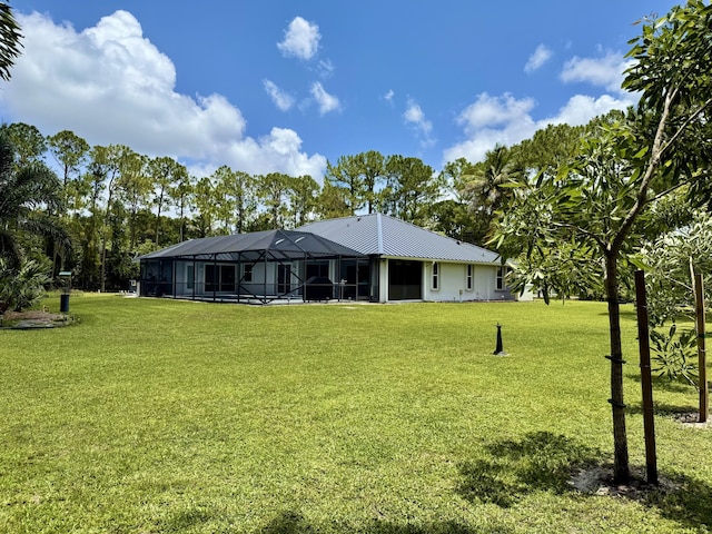 13021 150th Ct N, Jupiter, FL 33478 - back of house featuring a lawn, glass enclosure, and a metal roof
