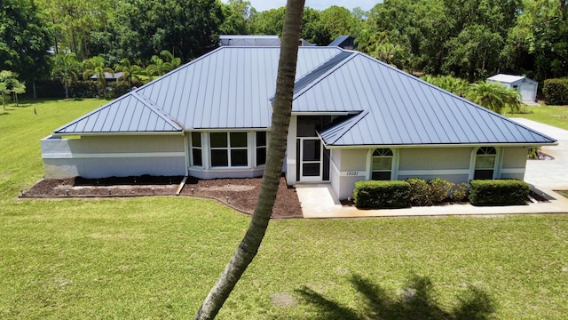 13021 150th Ct N, Jupiter, FL 33478 - view of front of home featuring a standing seam roof, a metal roof, and a front yard