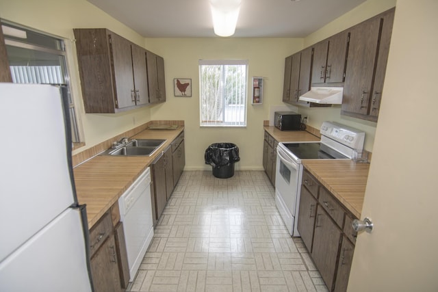 896 N Federal Hwy Unit 324, Lantana, FL 33462 - kitchen with white appliances, ventilation hood, brick patterned flooring, light countertops, and dark brown cabinets