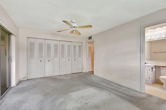 47 Camden Unit B, West Palm Beach, FL 33417 - unfurnished bedroom with carpet, a textured ceiling, connected bathroom, a ceiling fan, and a closet