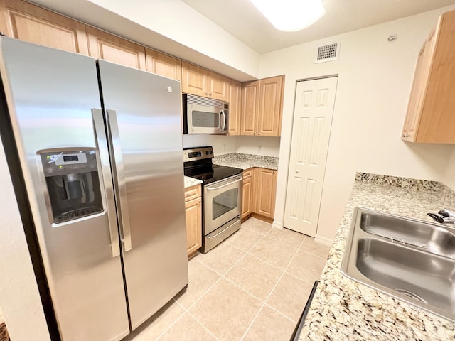 6761 Heritage Grande Unit 3303, Boynton Beach, FL 33437 - kitchen with stainless steel appliances, light brown cabinetry, light tile patterned floors, and light stone counters