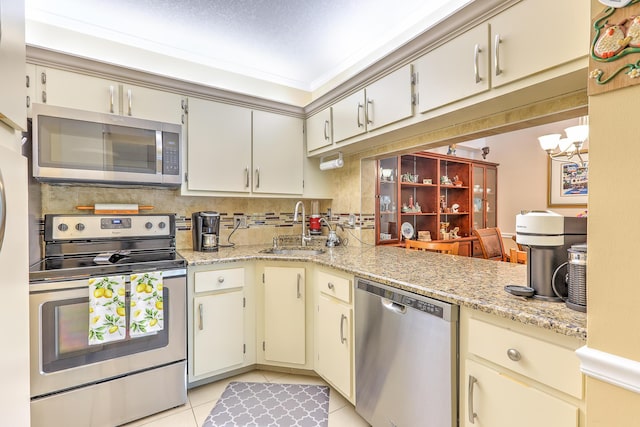 4452 NE Ocean Blvd Unit C2, Jensen Beach, FL 34957 - kitchen featuring appliances with stainless steel finishes, light tile patterned floors, a chandelier, and cream cabinets