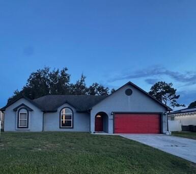 1142 SW Bayamo Ave, Port Saint Lucie, FL 34953 - ranch-style home featuring a garage, concrete driveway, a front yard, and stucco siding