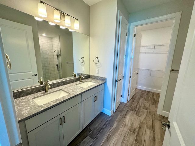 1236 Harper Way Unit 57, Vero Beach, FL 32960 - full bathroom featuring a stall shower, double vanity, a walk in closet, and wood finished floors