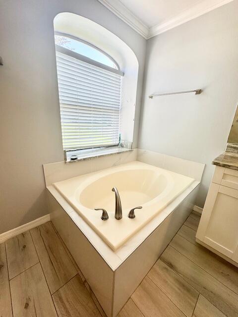 2681 SW Tanforan Blvd, Port Saint Lucie, FL 34953 - full bathroom featuring wood finished floors, a garden tub, ornamental molding, and vanity