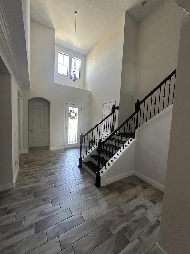 13106 Jeter Creek Dr, Riverview, FL 33579 - foyer featuring a chandelier, arched walkways, stairs, a towering ceiling, and wood finish floors