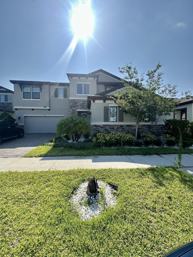 13106 Jeter Creek Dr, Riverview, FL 33579 - view of front of house featuring stucco siding, stone siding, a garage, driveway, and a front yard